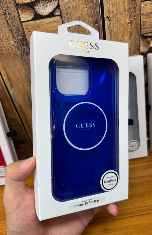 Blue phone case in Guess packaging held by a hand on a wooden surface
